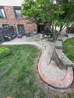 Backyard patio with winding path, seating area, and landscaped greenery. Ideal for outdoor relaxation.