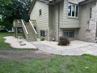 Modern home exterior with landscaped gravel yard, stairs, and pathway.