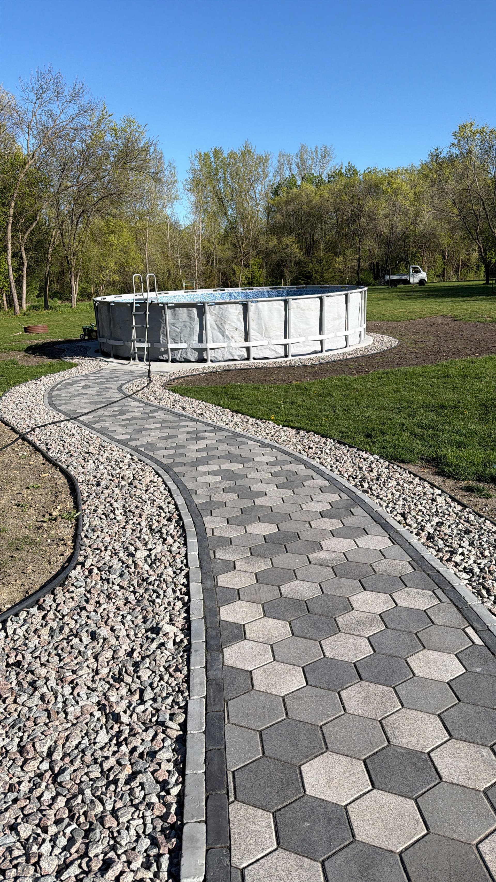 Curved Paver Walkway Leading to a Backyard Pool image
